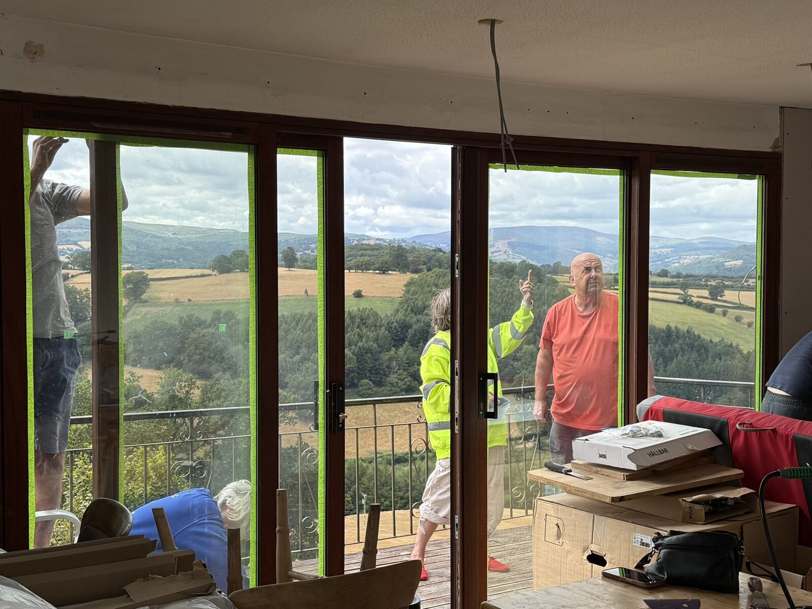Inside the annexe studio (the old No. 3) during the works: tidying up after the rewire and repairing the sliding doors, the valley visible through the glass
