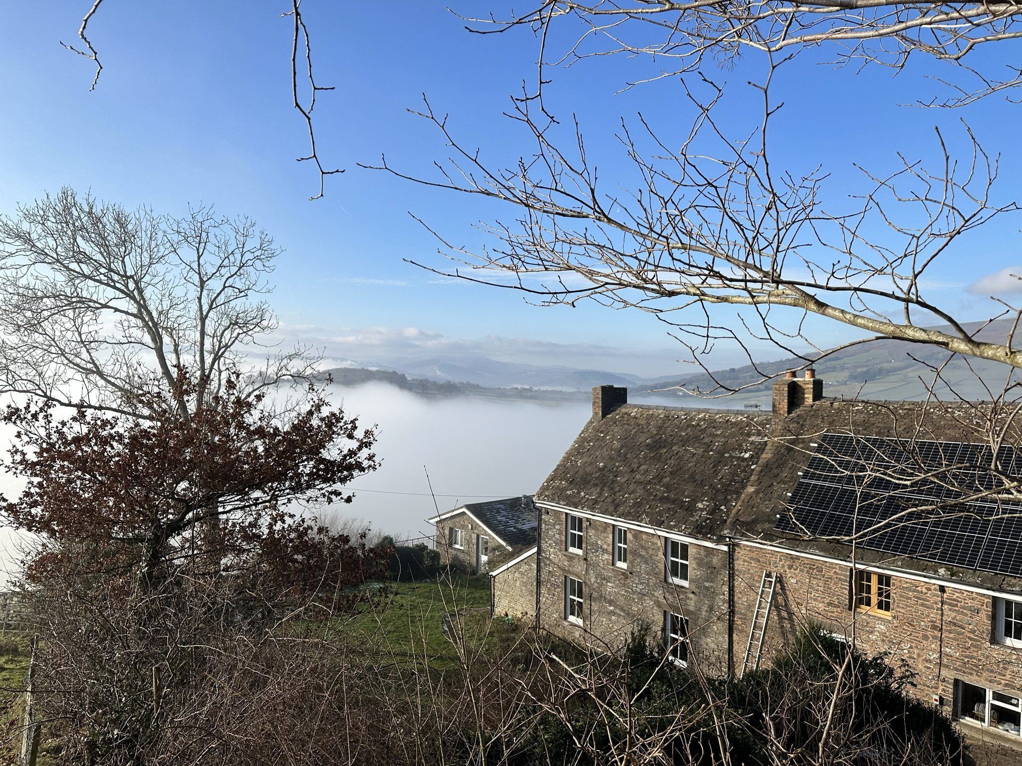 Pengilfach Cottages above a cloud inversion, the valley below filled with mist and the hills rising clear beyond