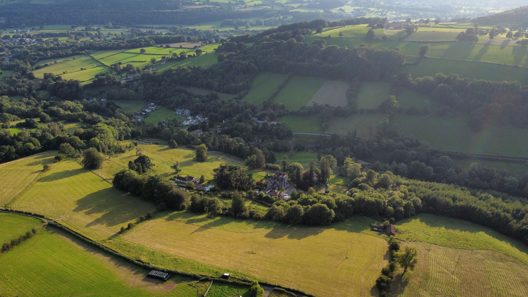 Drone view from the cottage of Pendarren House outdoor centre and Llangenny village in the valley below